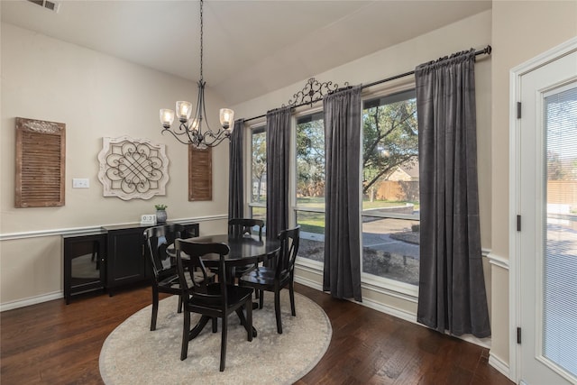 dining area with dark hardwood / wood-style flooring, plenty of natural light, and a notable chandelier