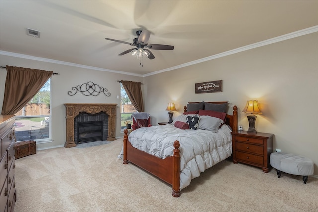 carpeted bedroom featuring multiple windows, ceiling fan, a fireplace, and ornamental molding