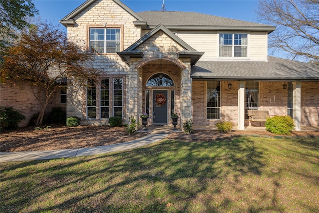 view of front of property with a porch and a front lawn