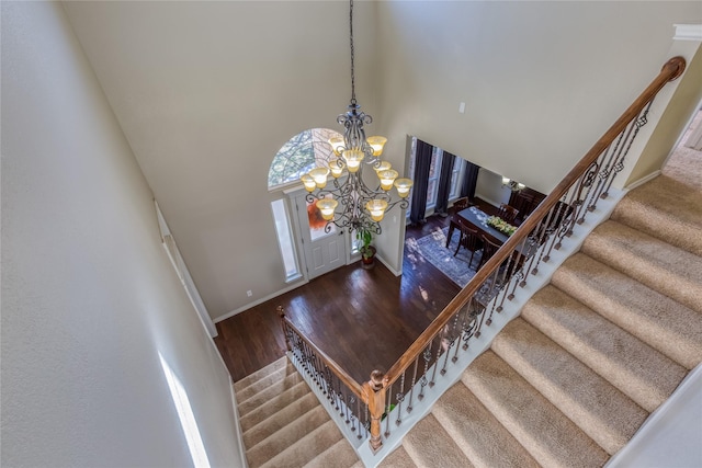 entrance foyer with hardwood / wood-style floors, a notable chandelier, and a high ceiling