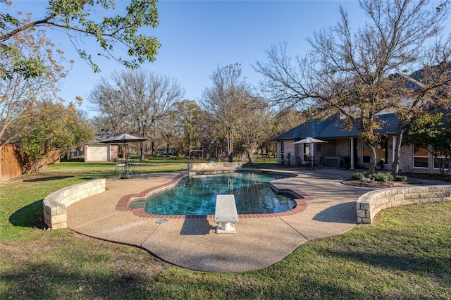 view of swimming pool with a diving board, a yard, and a patio