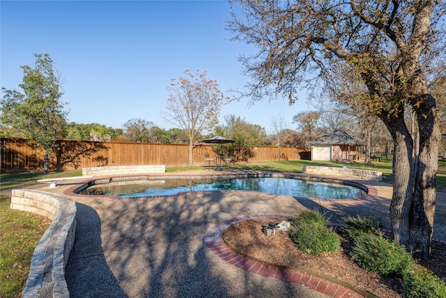 view of swimming pool with a diving board and an outbuilding