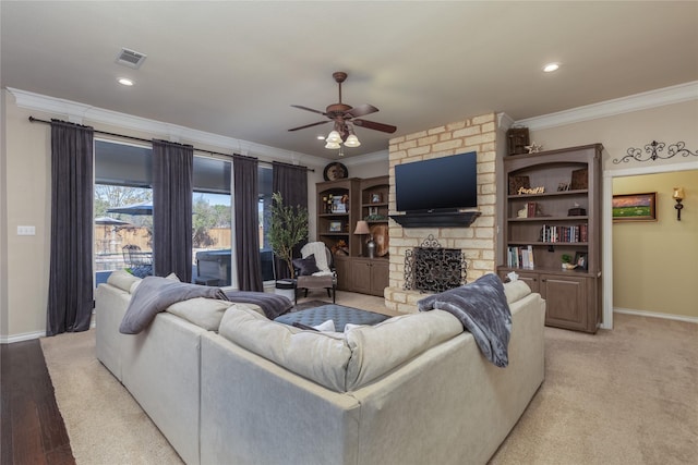 living room featuring ceiling fan, light hardwood / wood-style floors, ornamental molding, and a fireplace