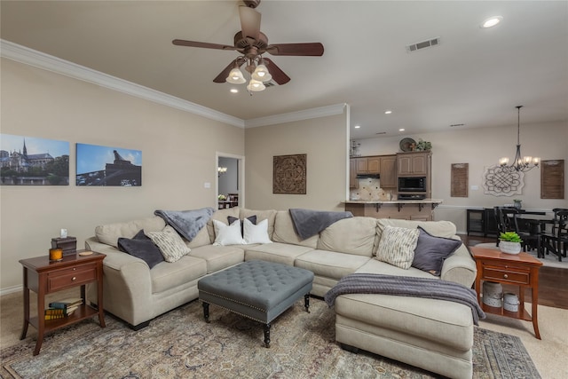 carpeted living room featuring ceiling fan with notable chandelier and crown molding