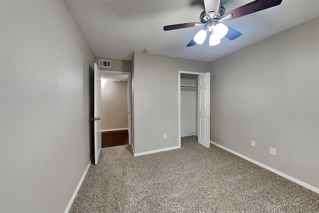 unfurnished bedroom with carpet, ceiling fan, a textured ceiling, and a closet