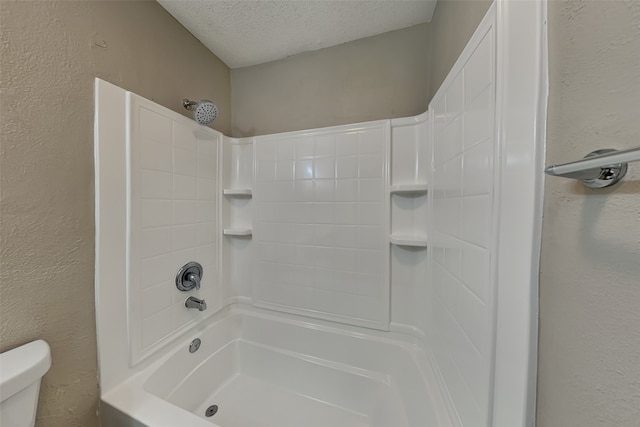 bathroom with a textured ceiling, shower / bath combination, and toilet