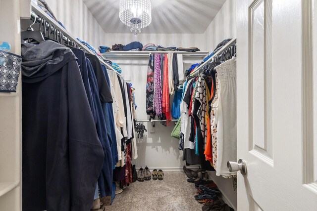 walk in closet featuring a notable chandelier and carpet floors