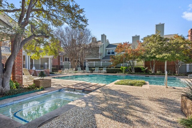 view of swimming pool featuring an in ground hot tub