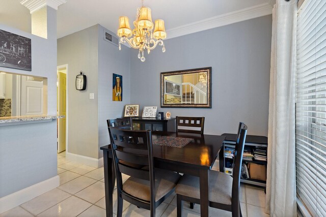 tiled dining space with an inviting chandelier and ornamental molding