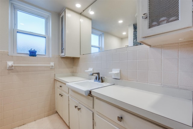 bathroom with tile patterned floors, vanity, and tile walls