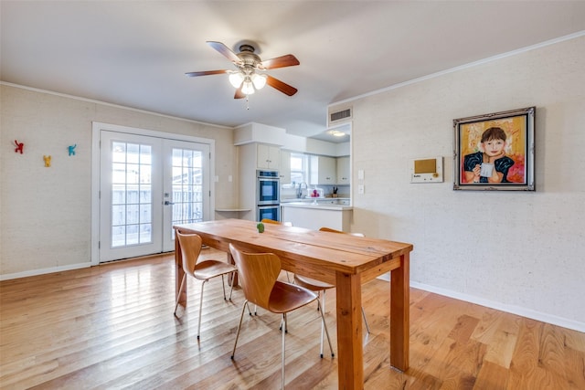 dining area featuring ceiling fan, french doors, sink, crown molding, and light wood-type flooring