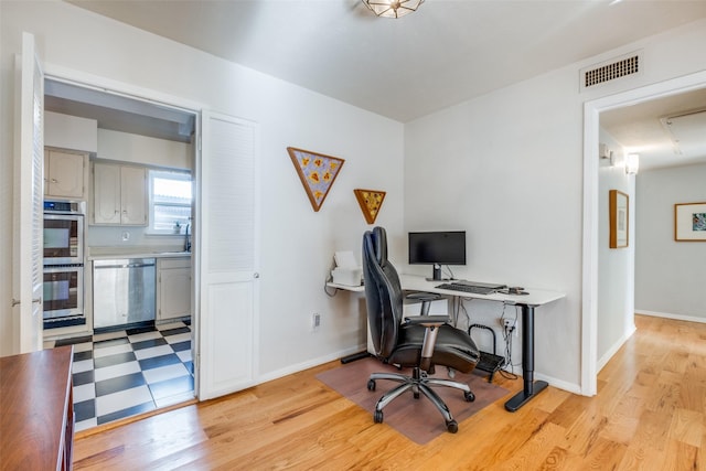 office area featuring light wood-type flooring and sink