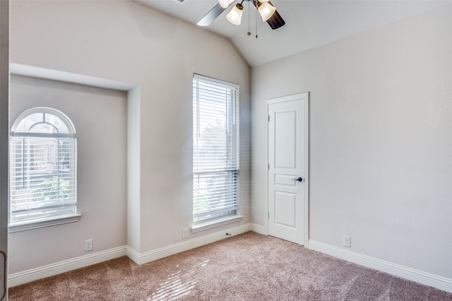 carpeted spare room with lofted ceiling, ceiling fan, and a healthy amount of sunlight