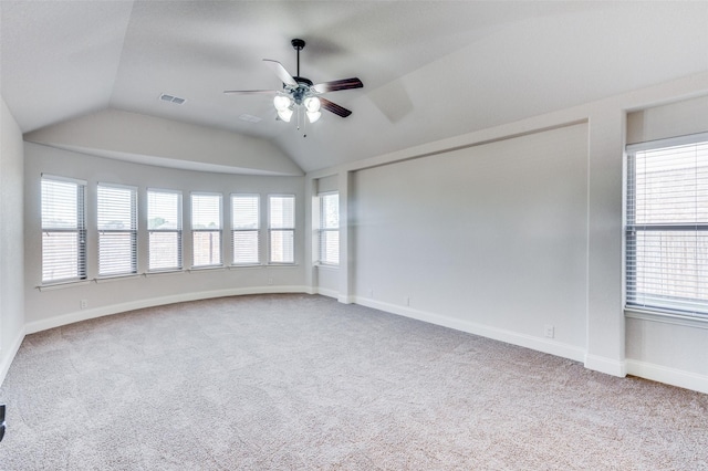 empty room with ceiling fan, light colored carpet, and vaulted ceiling