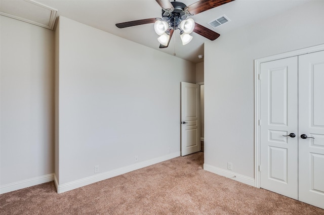 unfurnished bedroom featuring ceiling fan, a closet, and light carpet