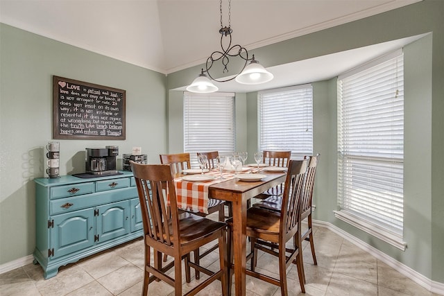 dining space featuring lofted ceiling, light tile patterned floors, and crown molding