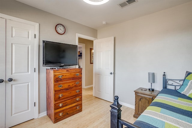 bedroom with light wood-type flooring and a closet