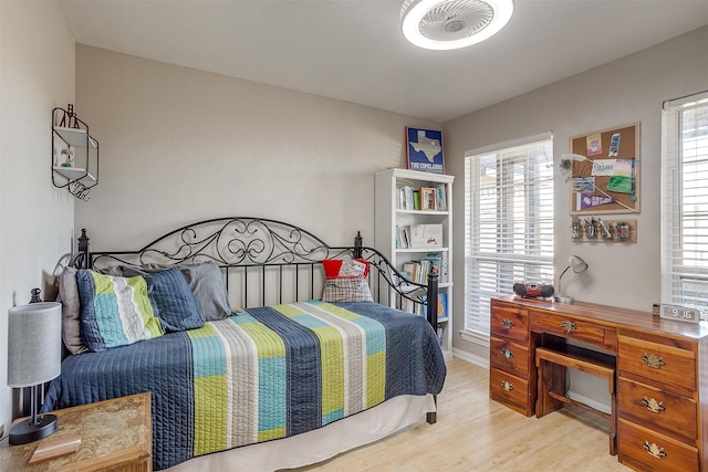 bedroom with multiple windows and light hardwood / wood-style floors