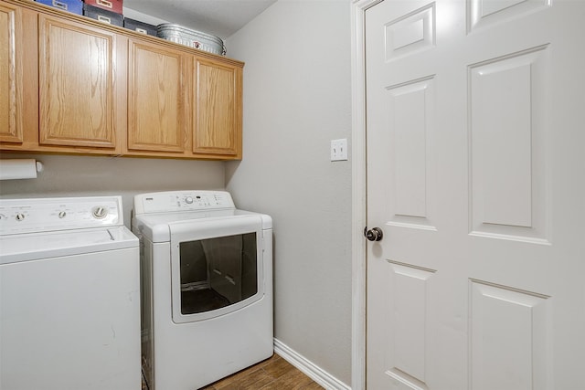 clothes washing area featuring dark hardwood / wood-style flooring, cabinets, and independent washer and dryer