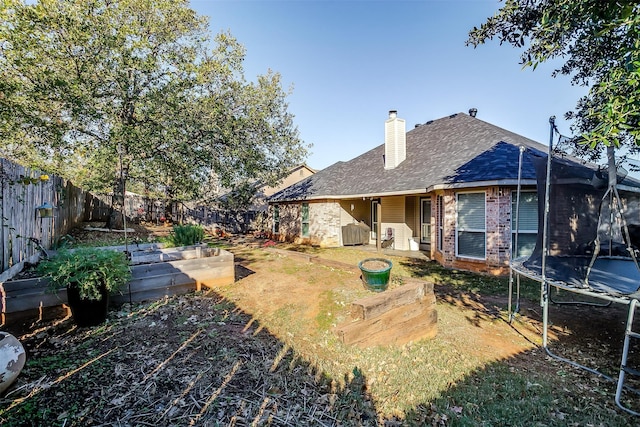 rear view of property with a trampoline