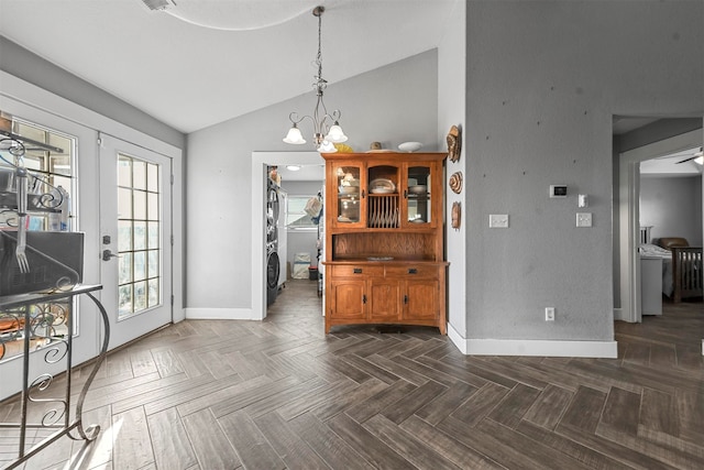 dining room with french doors, dark parquet floors, a chandelier, and vaulted ceiling