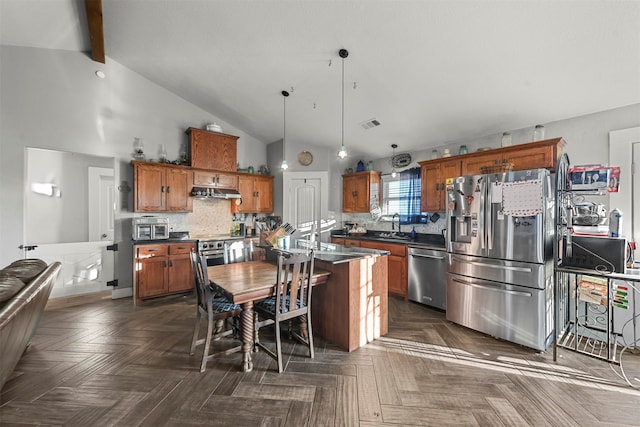 kitchen featuring sink, high vaulted ceiling, pendant lighting, a kitchen island, and appliances with stainless steel finishes