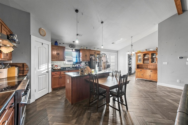 kitchen featuring dark parquet floors, tasteful backsplash, decorative light fixtures, a kitchen island, and stainless steel appliances