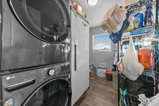 laundry room featuring dark hardwood / wood-style flooring and stacked washer / dryer