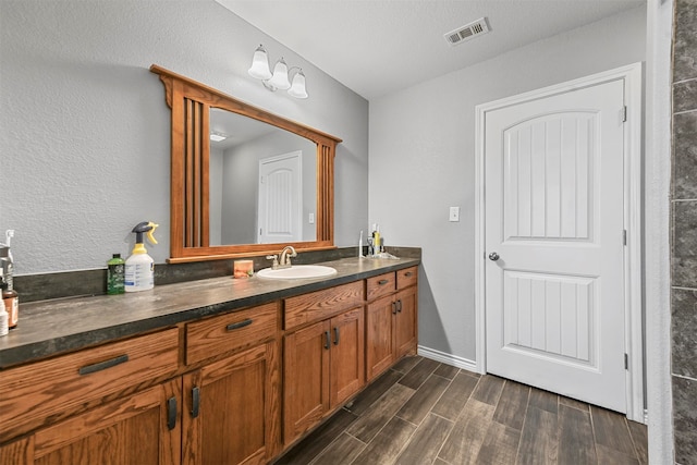 bathroom featuring vanity, wood-type flooring, and a textured ceiling