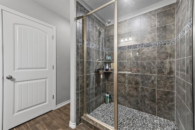 bathroom featuring hardwood / wood-style floors and a shower with shower door