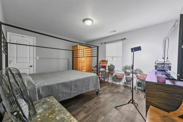 bedroom featuring a textured ceiling and dark wood-type flooring