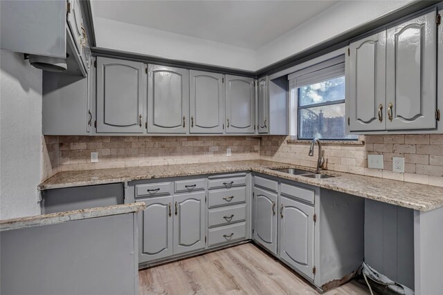 kitchen with light hardwood / wood-style flooring, gray cabinetry, and sink