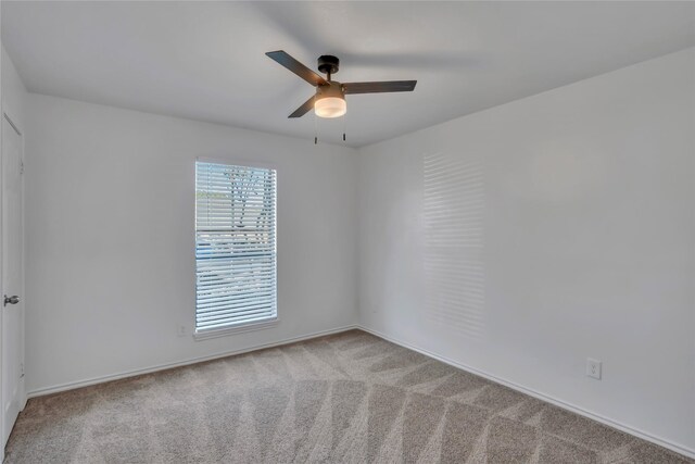 carpeted empty room featuring ceiling fan