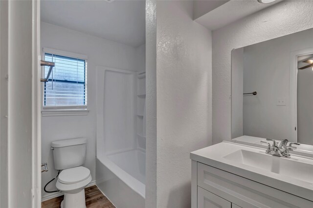 full bathroom featuring hardwood / wood-style floors, vanity, toilet, and shower / washtub combination