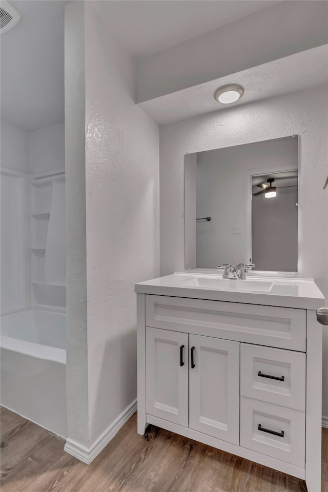 bathroom featuring hardwood / wood-style floors, vanity, and shower / washtub combination