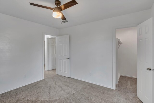 unfurnished room with ceiling fan and light colored carpet