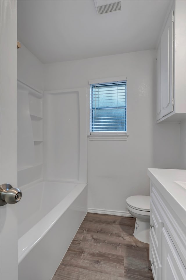 full bathroom featuring vanity, toilet, wood-type flooring, and shower / tub combination