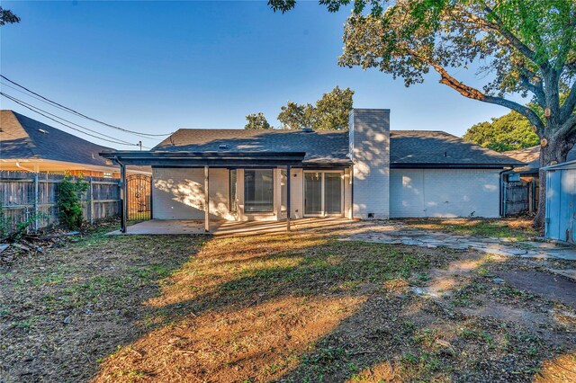 rear view of house with a yard and a patio