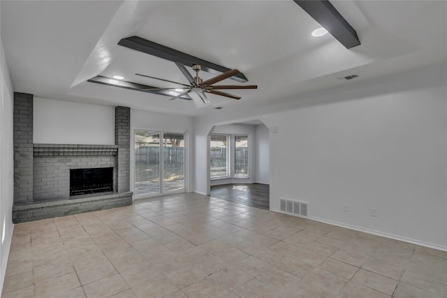 unfurnished living room with ceiling fan, a fireplace, and light tile patterned floors