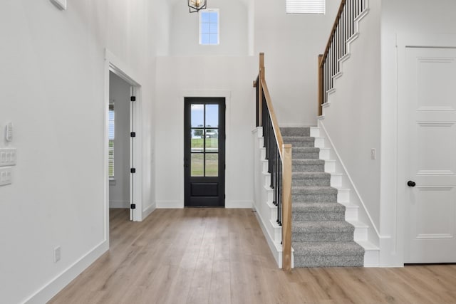 foyer with a high ceiling and light hardwood / wood-style floors