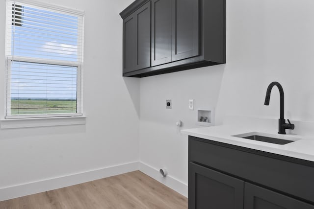 laundry area featuring electric dryer hookup, plenty of natural light, cabinets, and sink