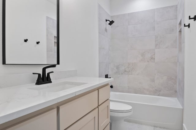 full bathroom with vanity, tiled shower / bath combo, and toilet