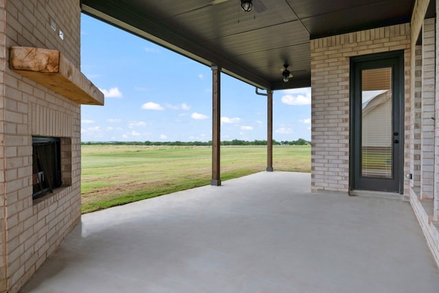 view of patio with ceiling fan and a rural view