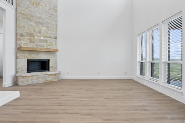 unfurnished living room featuring a fireplace and light hardwood / wood-style flooring