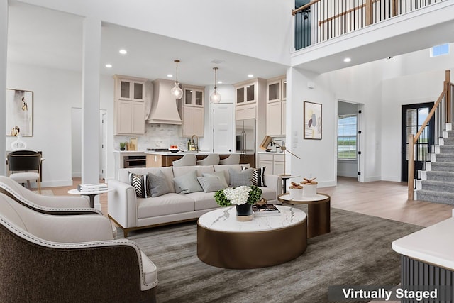 living room featuring dark hardwood / wood-style floors, sink, and a high ceiling