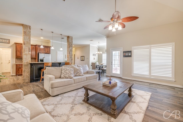 living room with ceiling fan with notable chandelier, dark hardwood / wood-style flooring, and ornamental molding