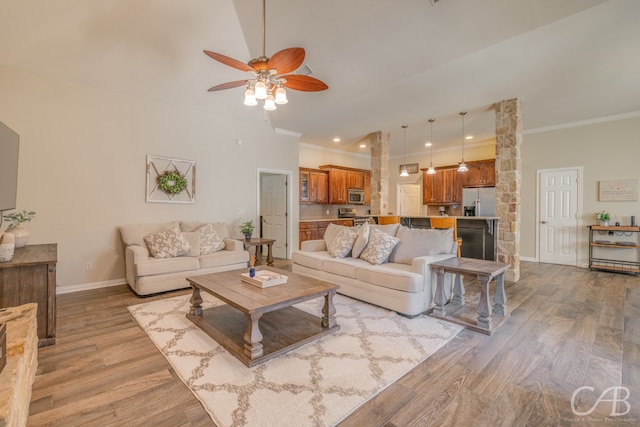 living room with ceiling fan, light hardwood / wood-style floors, and crown molding