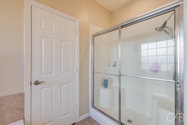 bathroom with tile patterned floors and a shower with shower door