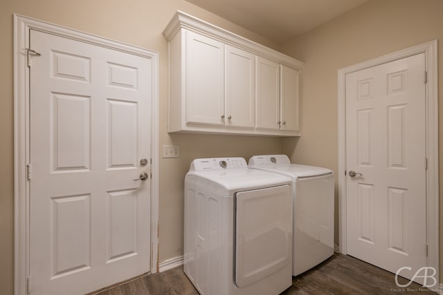 laundry area with cabinets, dark hardwood / wood-style flooring, and washing machine and dryer