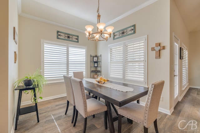 dining area featuring ornamental molding, wood-type flooring, lofted ceiling, and a notable chandelier